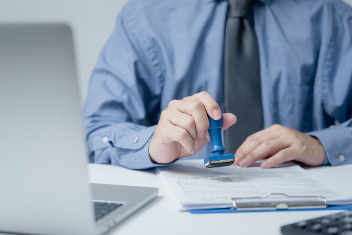 Authority representative stamping an approved permit for a remodeling project