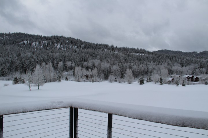 Snow-covered landscape viewed from a deck during winter