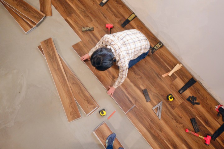 Worker installing wooden flooring during a home renovation project