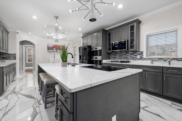 Fully renovated kitchen with gray cabinets and marble floors