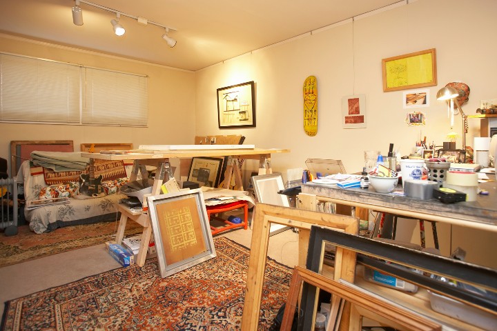 Garage converted into an art studio with paintings, easels, and workstations