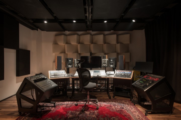 Garage transformed into professional music studio with acoustic panels and mixers