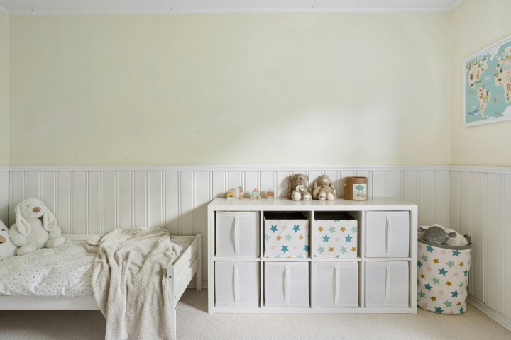 Garage transformed into child’s playroom with cozy bedding and toy storage