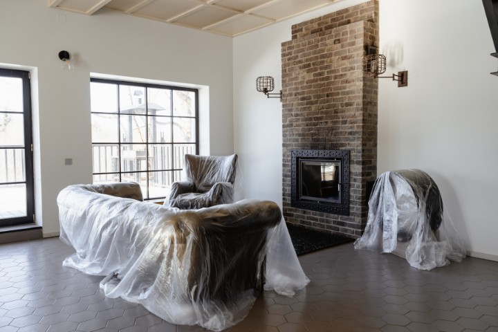 Home prepared for remodeling with furniture covered in protective dust sheets