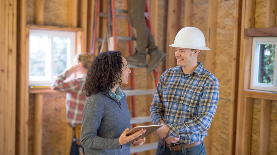 homeowner and remodeling contractor discussing renovation checklist Homeowner with tablet meeting contractor to review remodeling checklist
