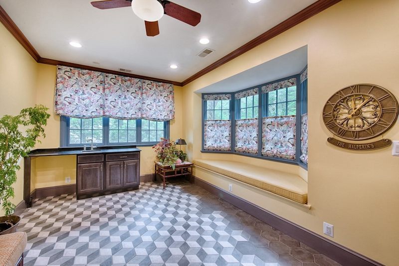 Colorful bump out addition featuring patterned floors, bay windows, and built-in seating area