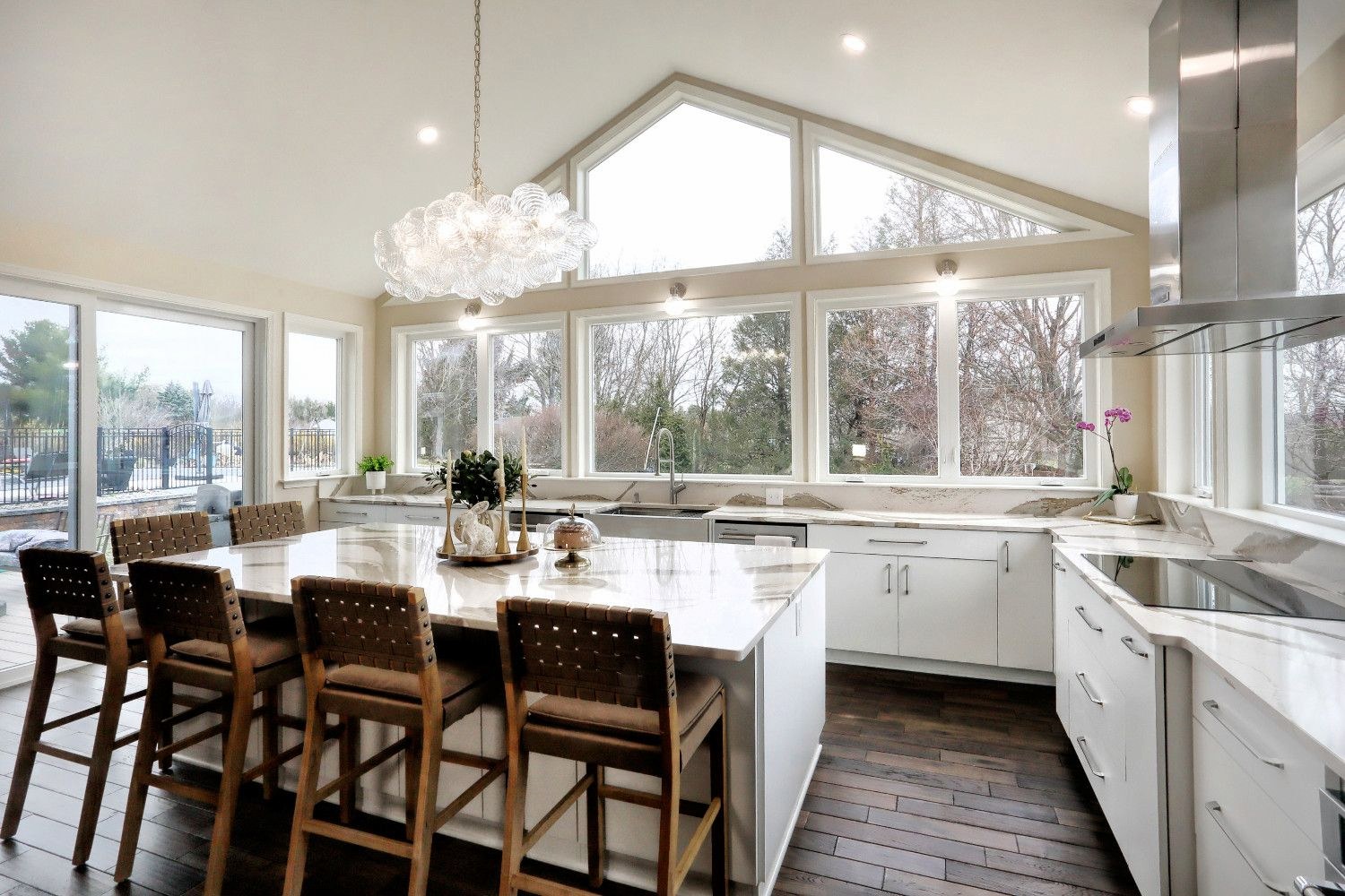 Bright minimalist kitchen interior in Anne Arundel county with marble countertops and stylish lighting fixtures