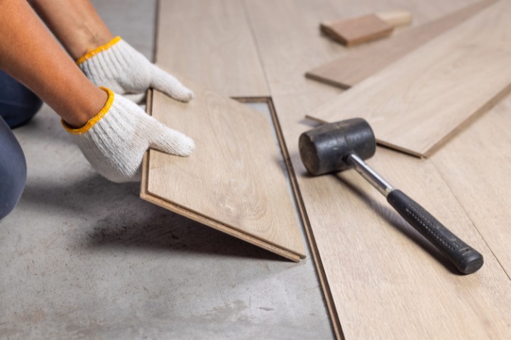 Contractor installing wood flooring during a home renovation project