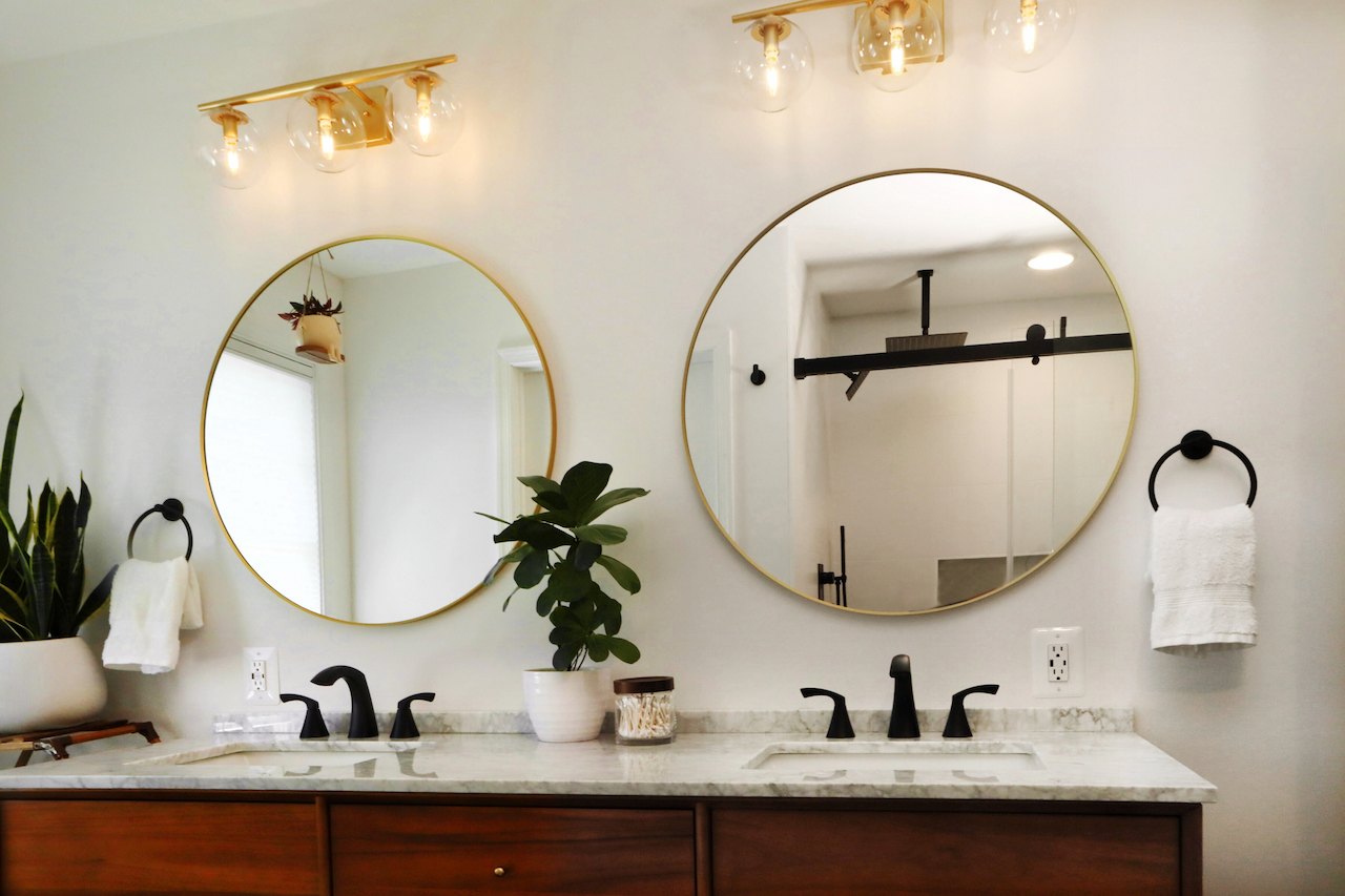 Bathroom interior showcasing refined Maryland design with marble countertops and matte black faucets
