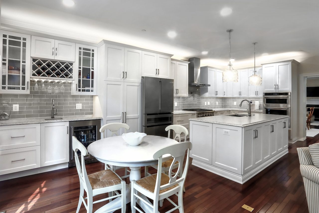 kitchen remodel featuring white cabinets, marble countertops, and a central island