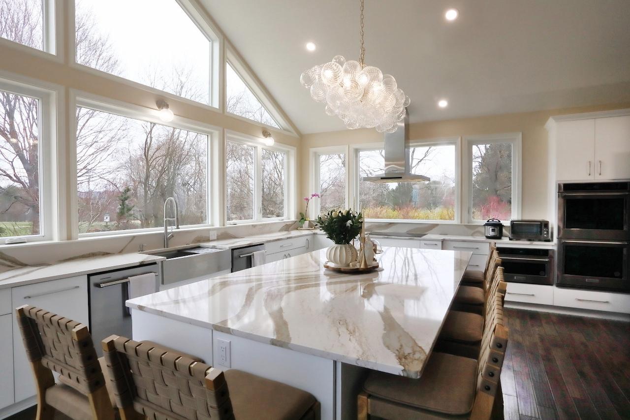 Modern kitchen addition in Maryland featuring large windows, marble island, and open layout