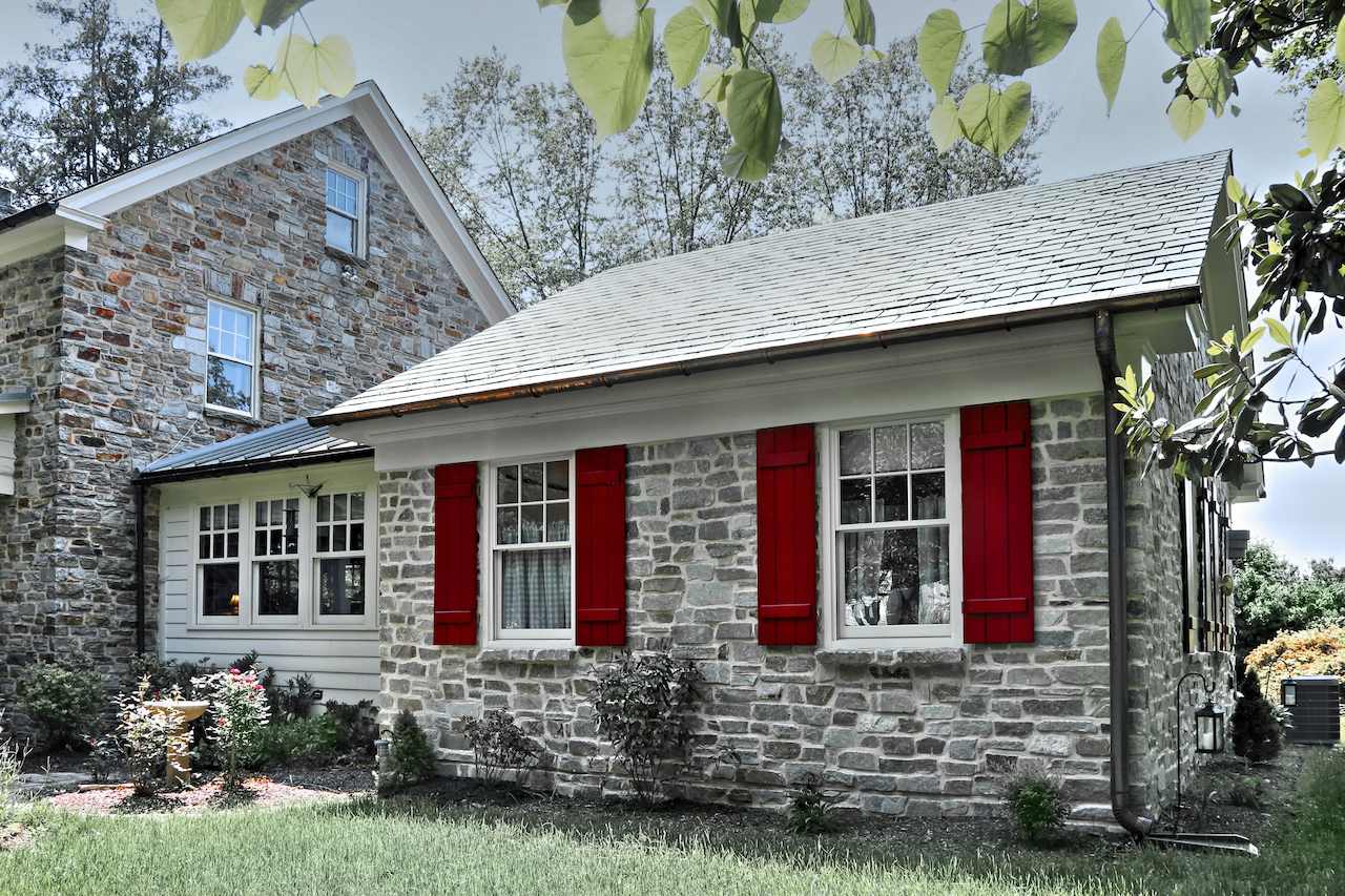 In-law apartment addition in Maryland featuring stone exterior and red window shutters