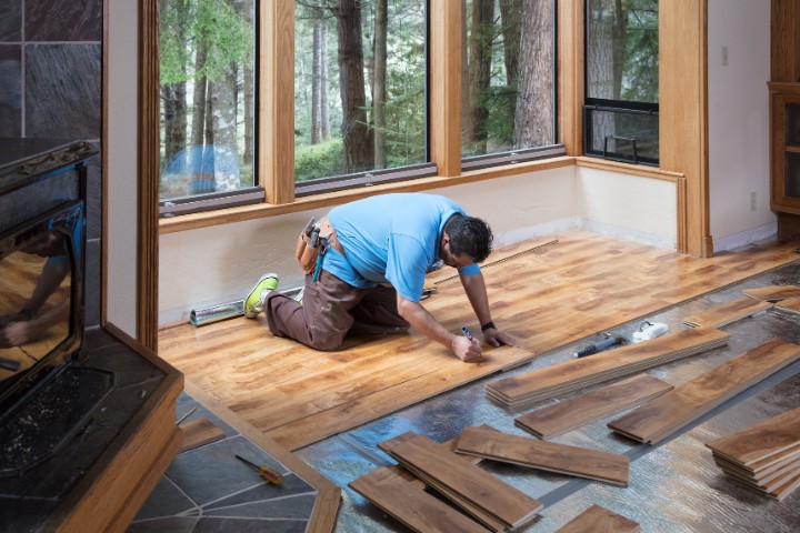 Craftsman installing durable hardwood floors for a home addition in Maryland