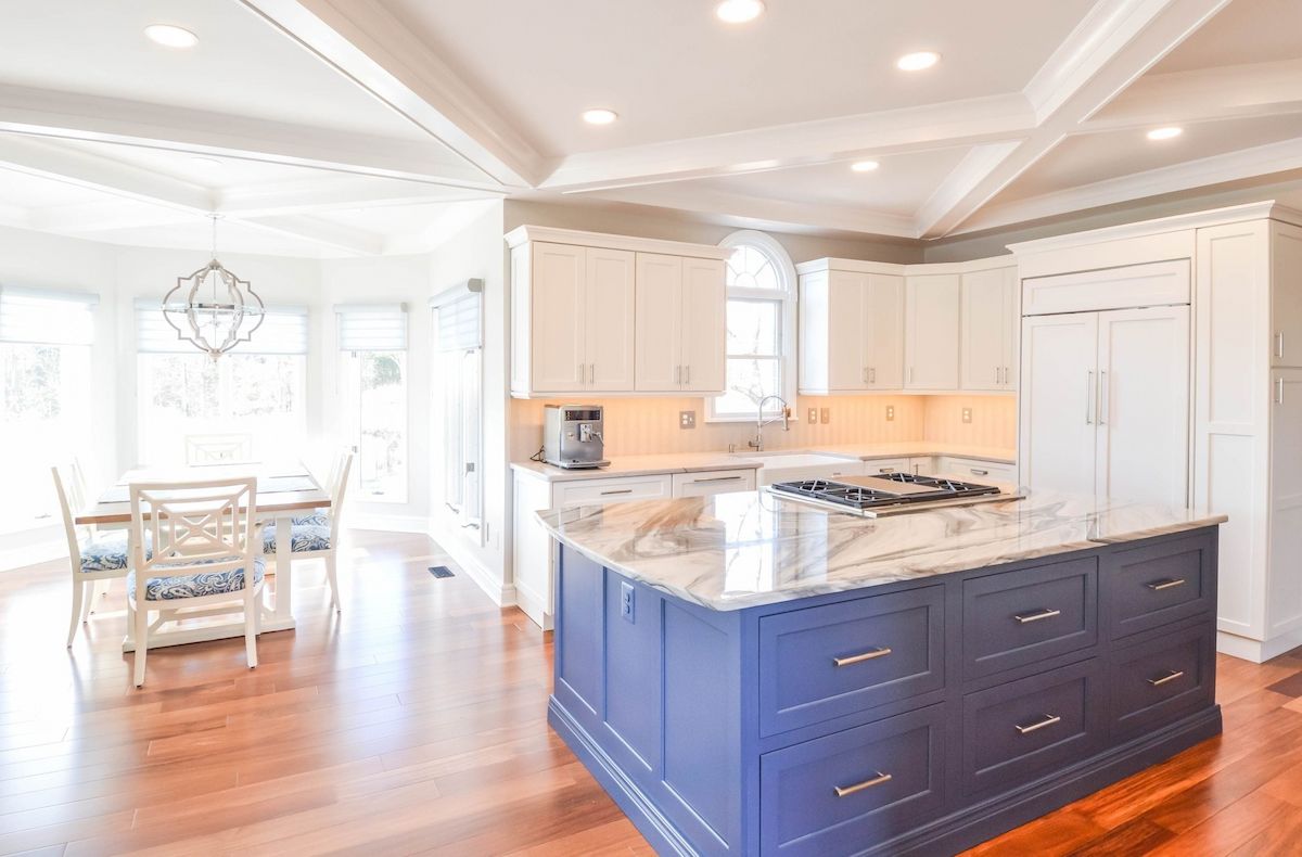 spacious white kitchen with custom cabinetry and bold blue island designed by a home remodeler in maryland