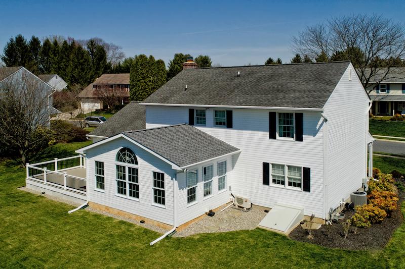 exterior home renovation project featuring a newly built sunroom addition and upgraded deck on a suburban maryland home