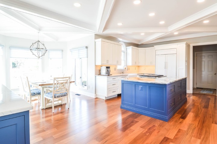 Maryland open concept remodel featuring a bold blue island, white cabinets, and natural light