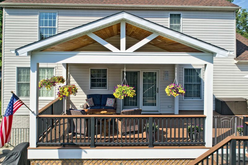 Home addition in Harford County showcasing a second-level extension and a beautiful covered deck with wood accents