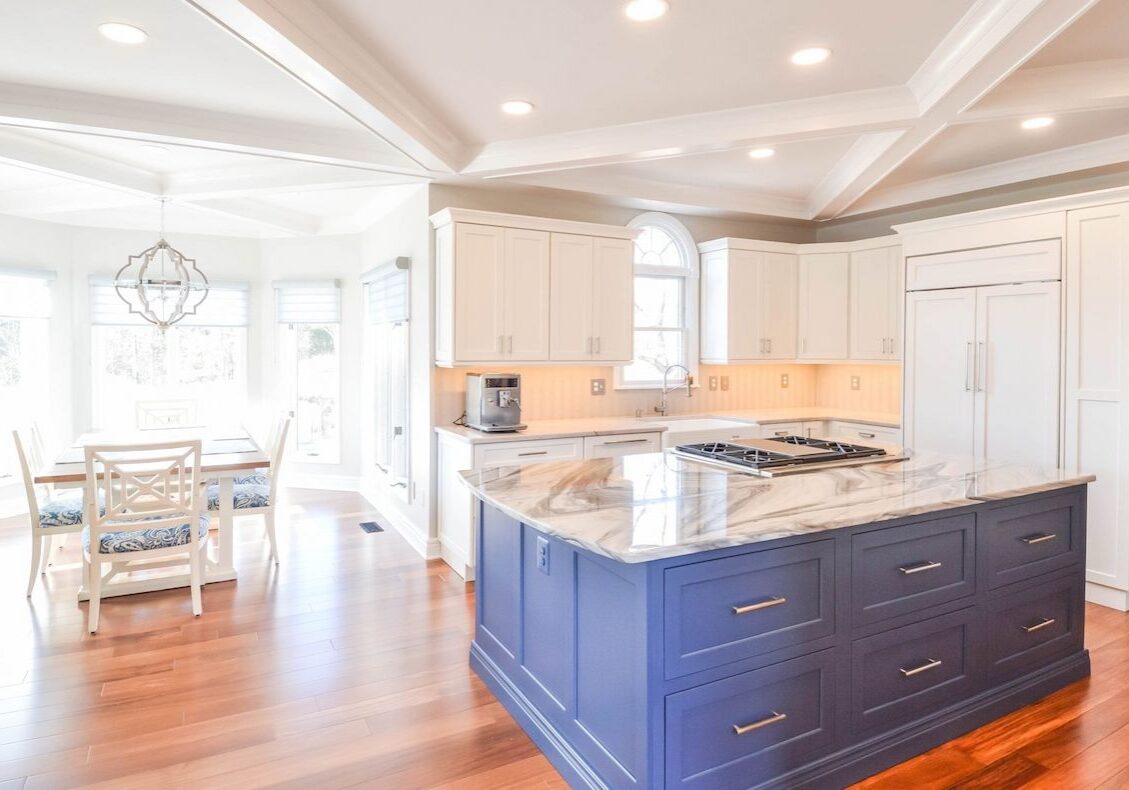 spacious white kitchen with custom cabinetry and bold blue island designed by a home remodeler in maryland