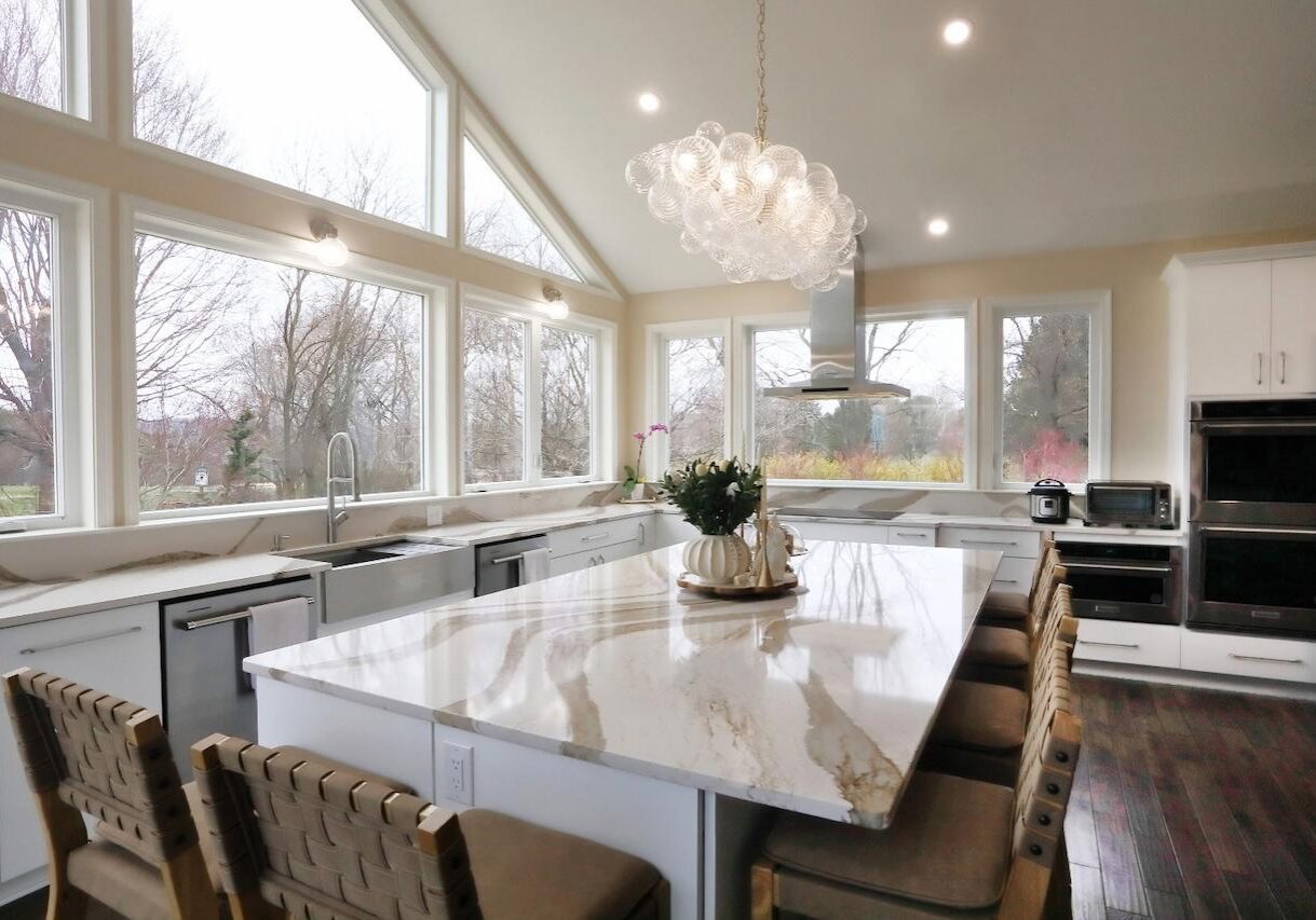 Modern kitchen addition in Maryland featuring large windows, marble island, and open layout